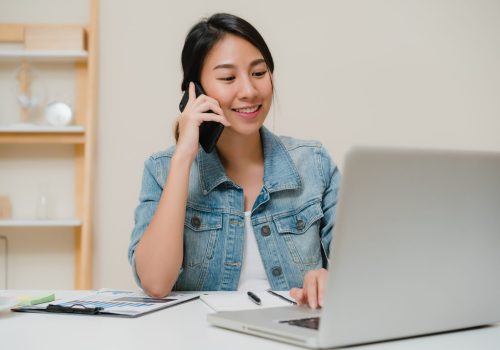 beautiful smart business asian woman smart casual wear working laptop talking phone while sitting table creative office scaled.jpg